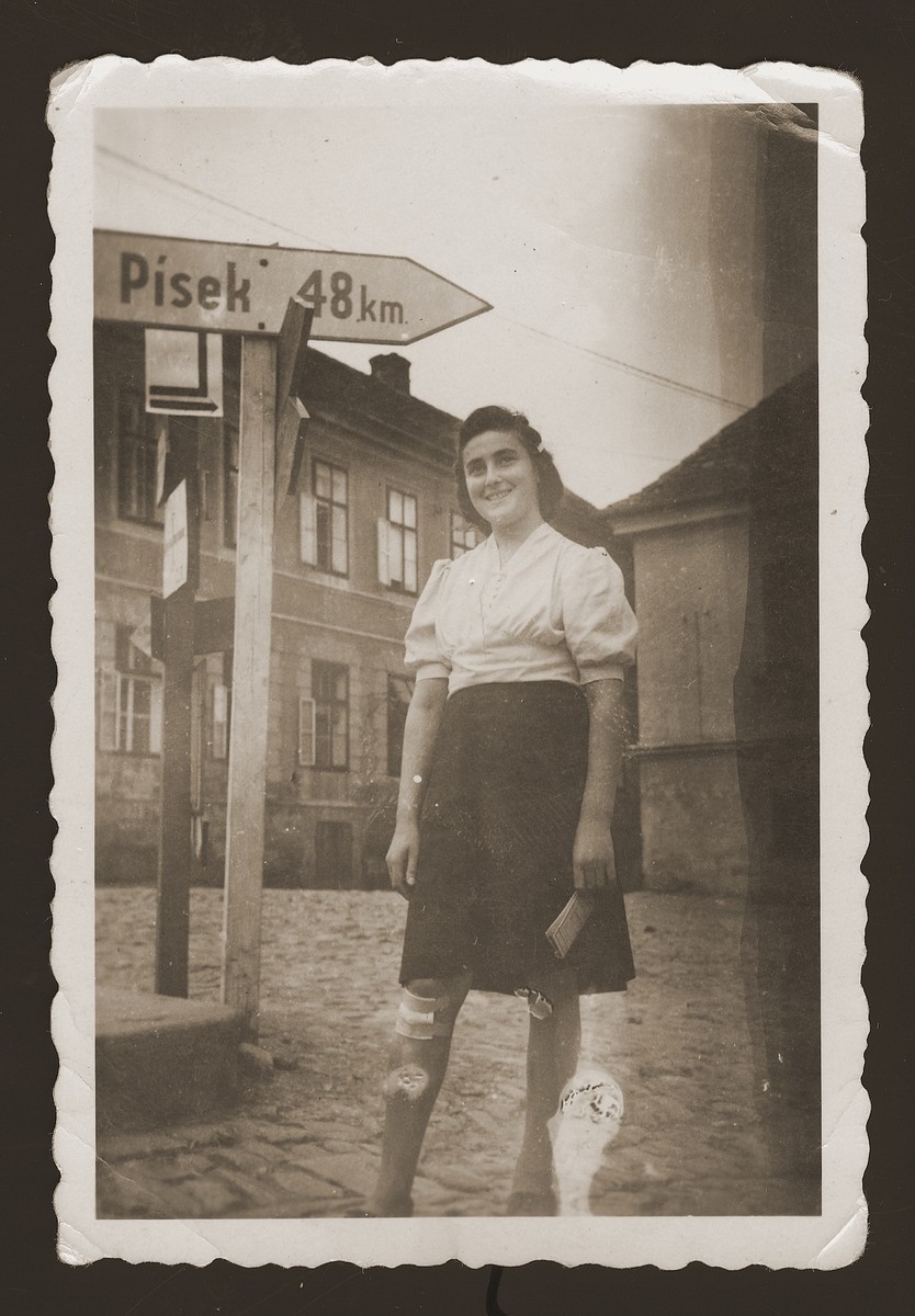 A young Jewish woman poses next to a road sign in the New Palestine displaced persons camp.

Pictured is Lilka Zylbygier.