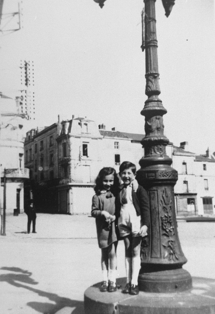 Two children stand next to a lamp-post in Loudun. 

Pictured are Liane Reif and Jean-Paul Berg.
Jean-Paul Berg, Liane's friend perished during the Holocaust.