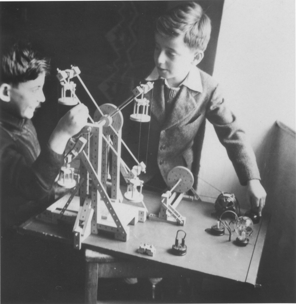 Wolfgang Schaechter (right) and Marcel Brettler (left) play with a mechanical erector set in the Enns displaced persons camp.