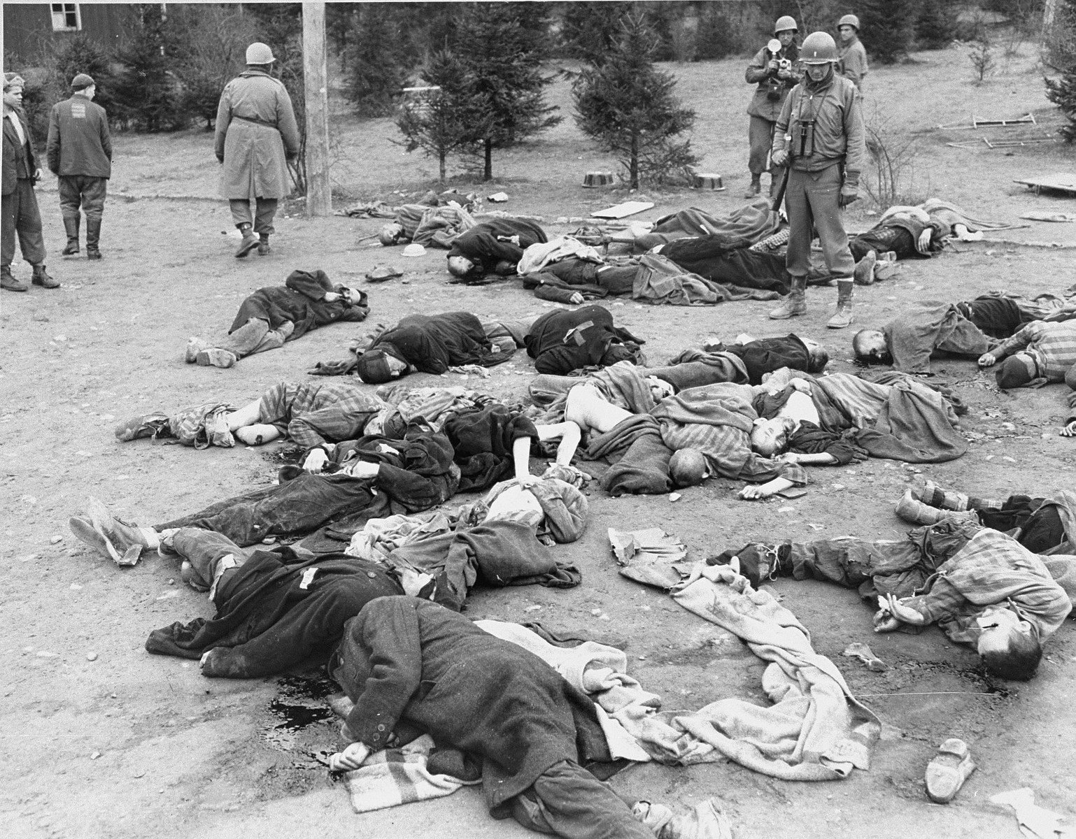 American soldiers view the bodies of prisoners that lie strewn on the ground in the newly liberated Ohrdruf concentration camp.

1st Lieutenant Earl J. Kelly is standing on the right.