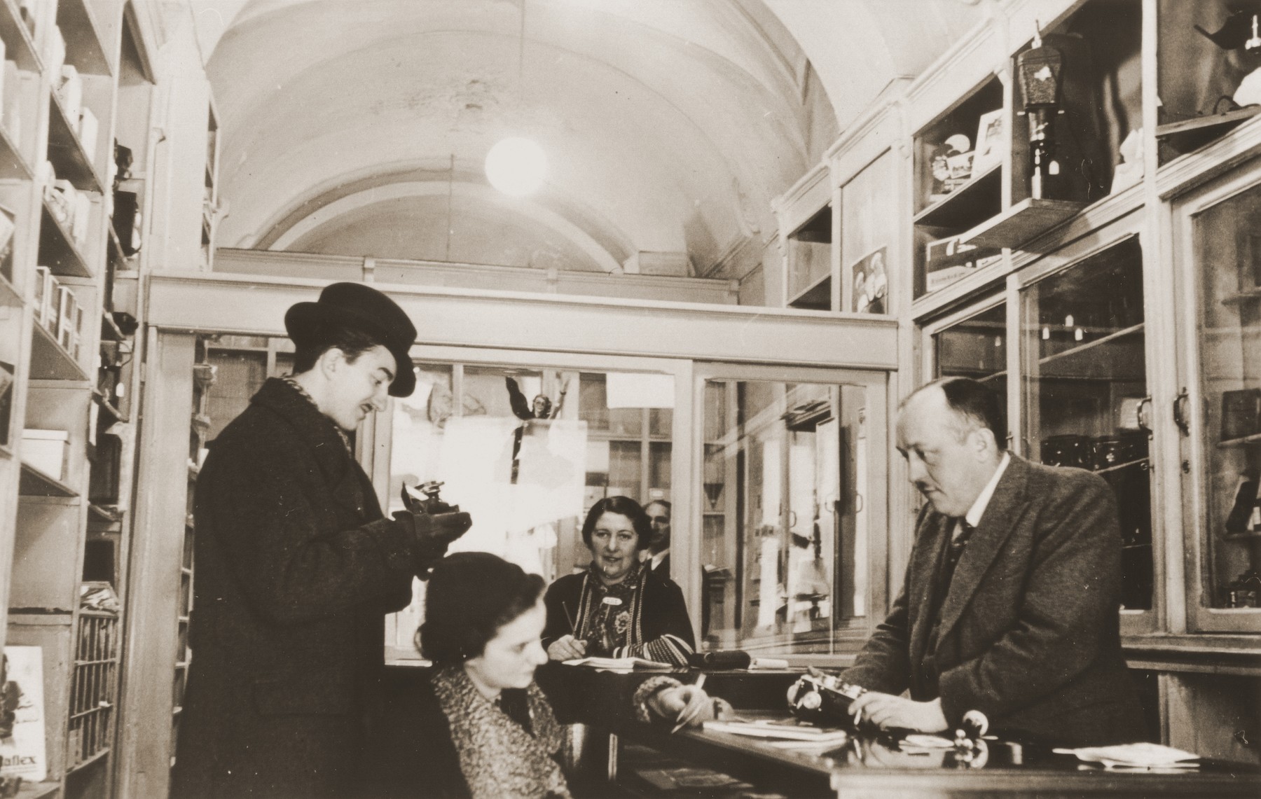 Raffael Brenner assists customers in his photography shop in Rome.