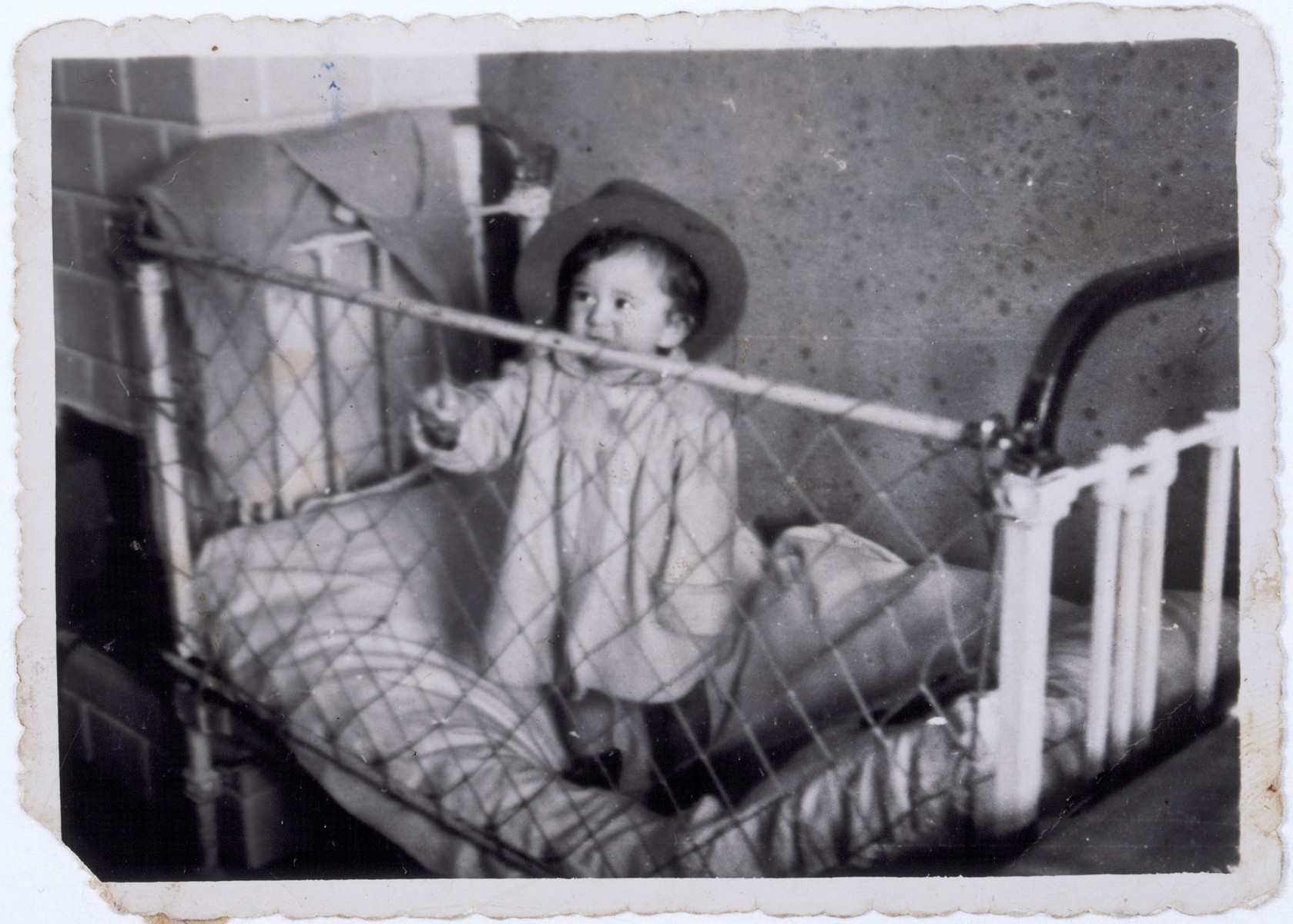 Jurek Kaiser standing in his crib in the Kielce ghetto.