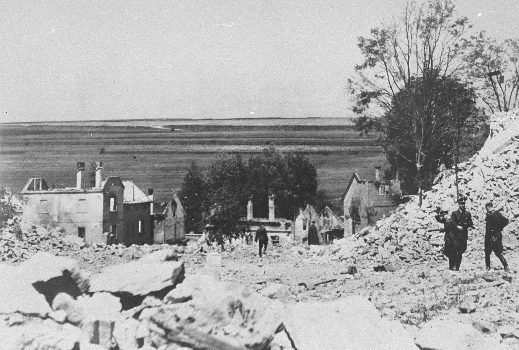 SS officers stand among the rubble of Lidice during the demolition of the town's ruins.