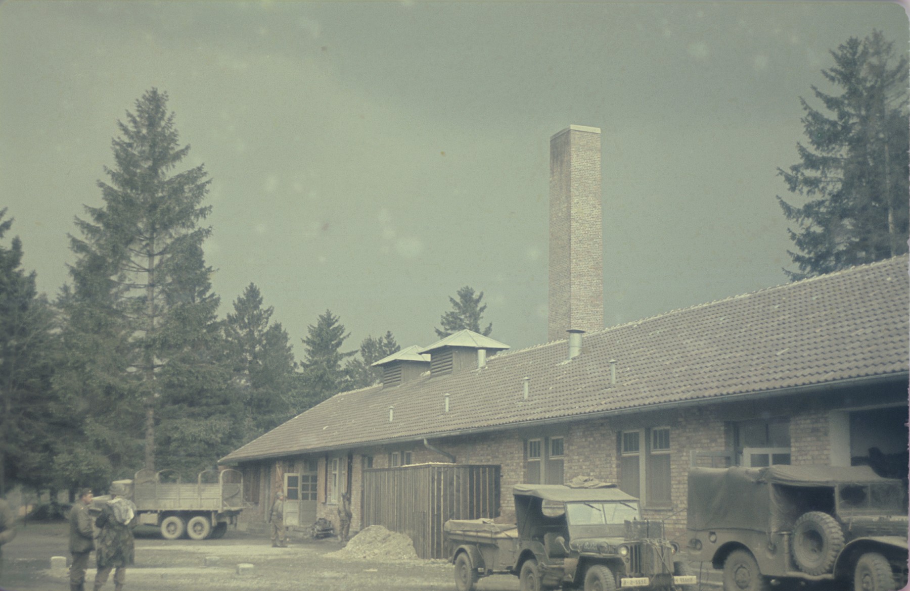 Trucks are parked in front of the crematorium in the newly liberated Dachau concentration camp.