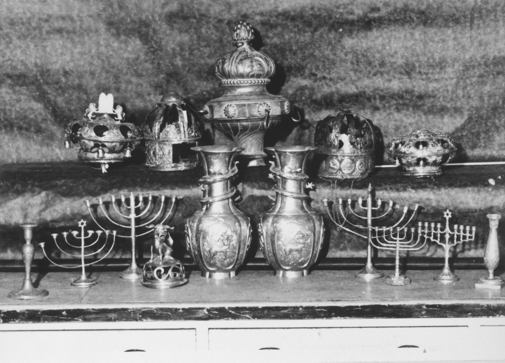 Display of silver Hanukkah menorahs, torah crowns and other ritual articles confiscated by the Nazis.