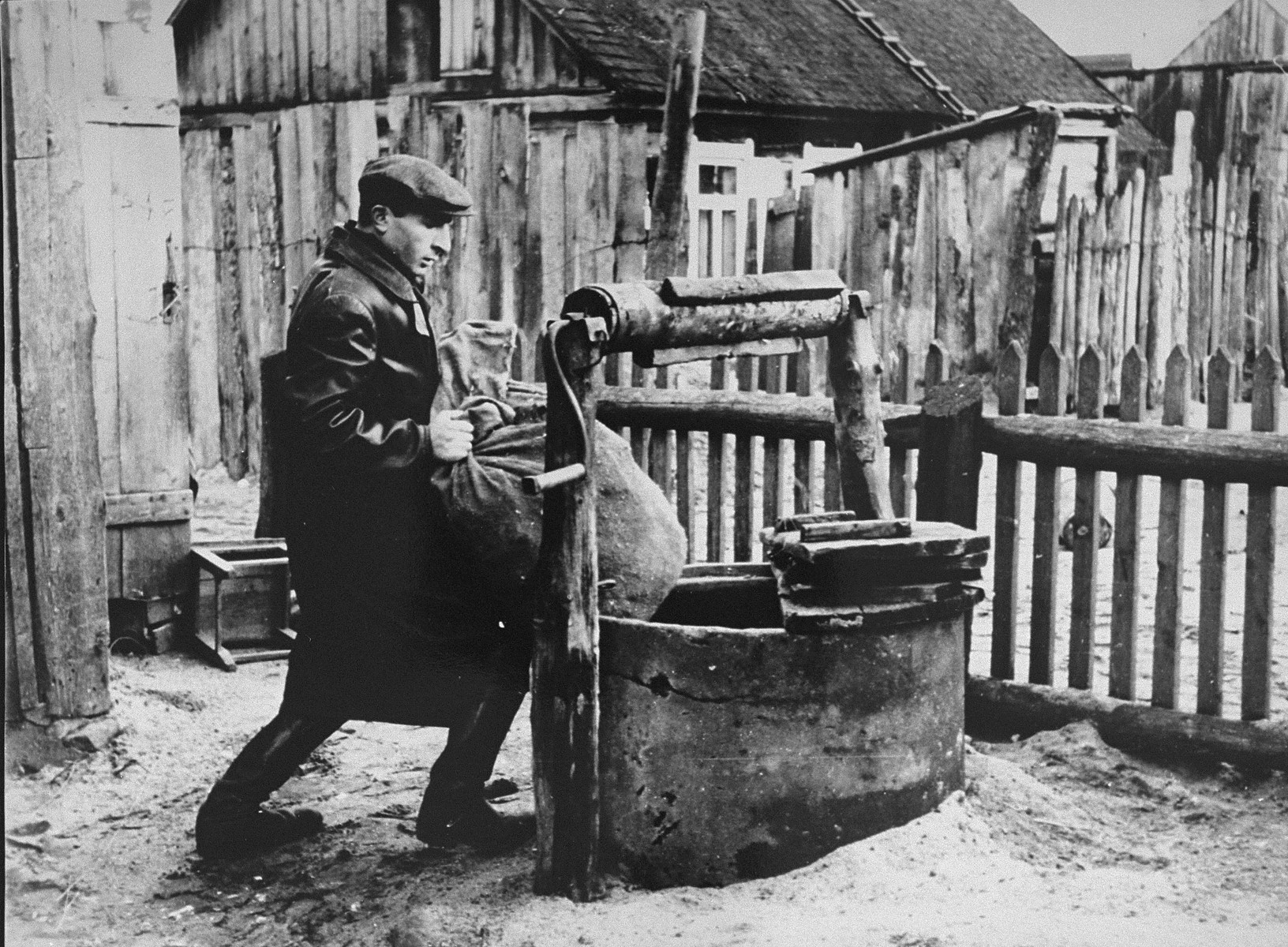 Judke (Yehuda) Levitt hides supplies in the well. Jews in the Kovno ghetto started to build and prepare hide outs, bunkers,(melinas) for storage of food, medicine, guns, etc.