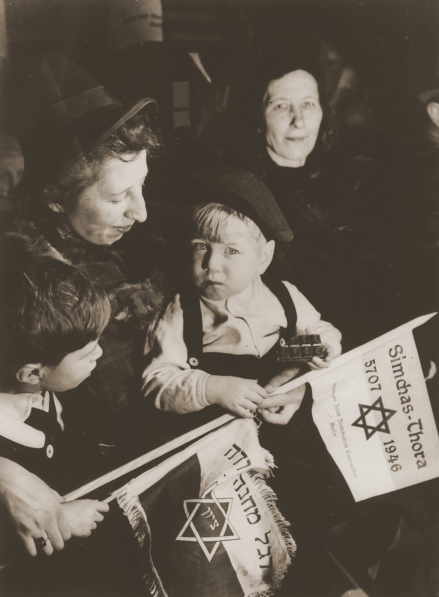 Two little boys holding toy flags attend a Simchat Torah celebration at the Schlachtensee displaced persons camp.