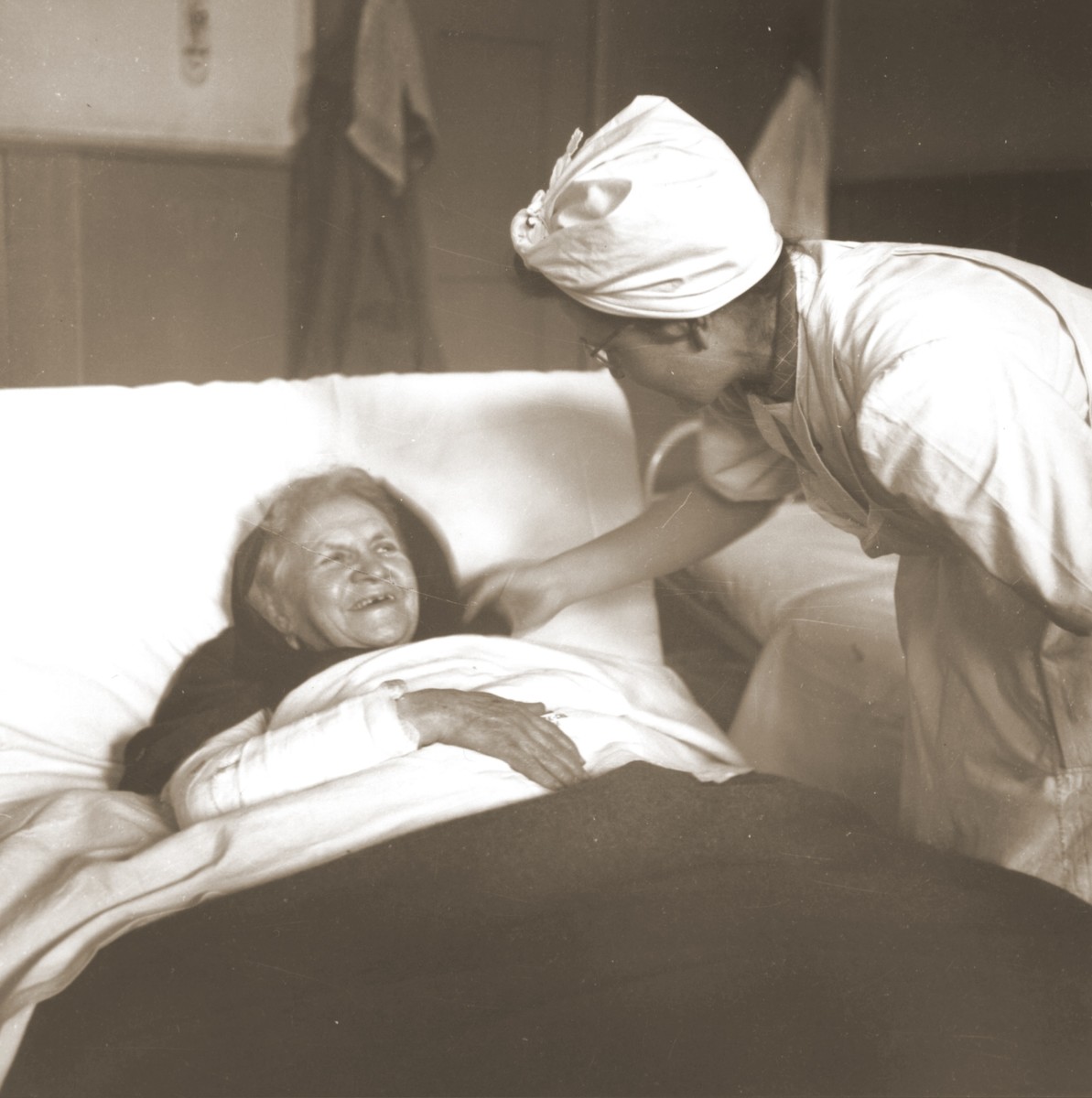 An elderly Jewish woman rescued from Theresienstadt  receives medical attention from a Swiss Red Cross worker in the infirmary of the Hadwigschulhaus in St. Gallen