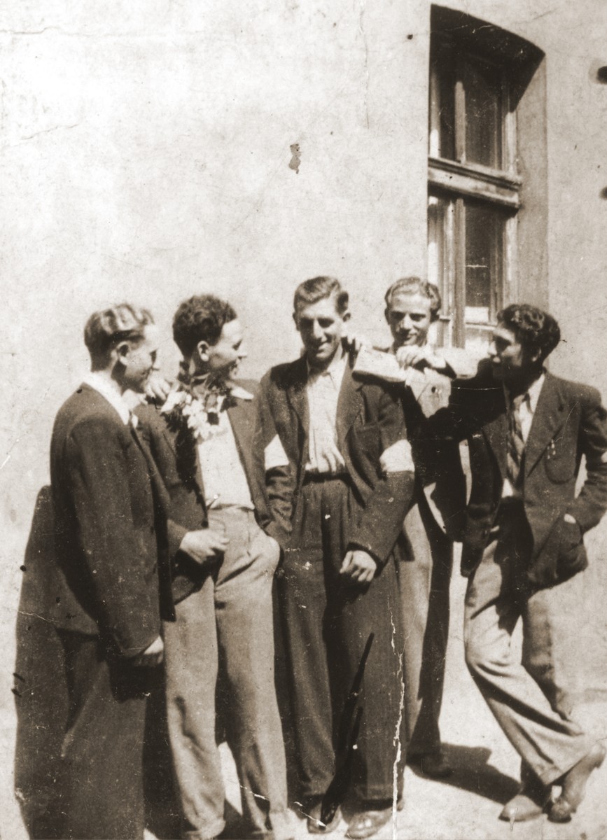 A group of friends gather outside a house in the Bedzin ghetto.

Standing from left to right are Abraham Faymann, Moniek Bronner, Motek Faymann, unknown, and Moniek Klugman.