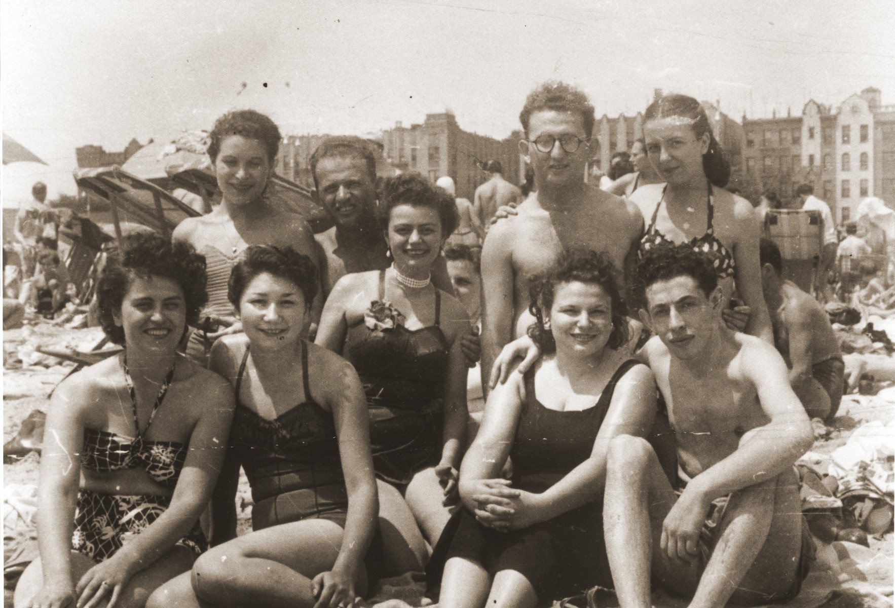 Young Jewish men and women who came to England with the orphans transport relax on the beach.

Pictured in the back row, from left to right are, Lillie Moskovich, Willie Zelovic, Erica Grossman (center wearing a necklace), Hershel and Renate Zelovic.  In the front row, from left to right are, Paulette, Elizabeth Weiss, and Ibi and Willie Rosenberg.