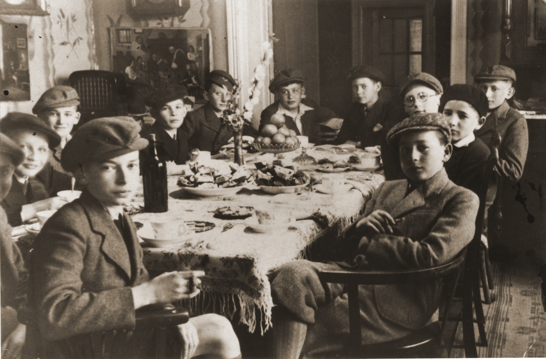 Robert Vermes (at the back head of the table, third from the right) entertains a group of friends at a bar mitzvah party in his home in Topolcany, Slovakia.  Almost all of the boys were killed during the war.