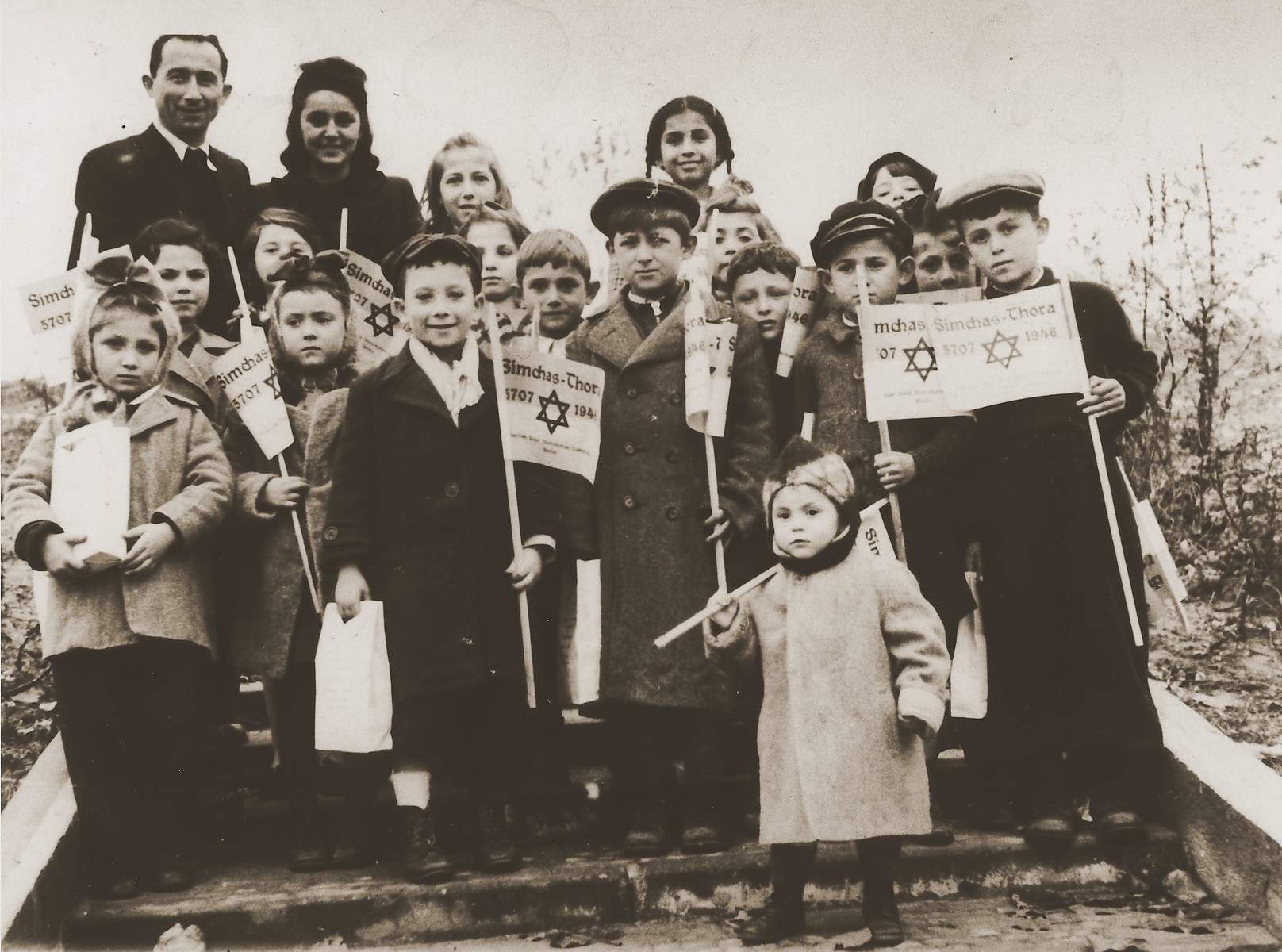 Group portrait of children holding toy flags for Simchat Torah at the Schlachtensee displaced persons camp.

Among those pictured are Rachel Kosowski (top row, second from the left) and Joseph Shefsky (first row, second from the right).