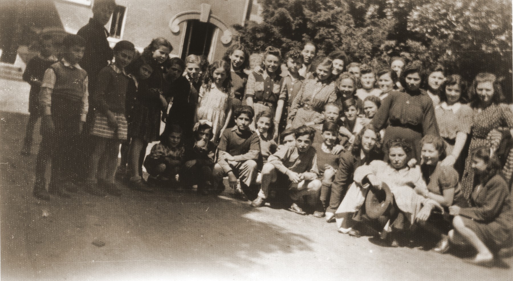 Group portrait of members of the orphans transport during their sojourn in France on their way to England.

Among those pictured are S. Lampert, Mermelstein, E. Zelovic, Vermes, Markovits, Weinberger, M. Lampert, W. Zelovic, Weiss, Davidovic, Lebovic, Slomovic, Birnbaum, Zelikovic and Bohm.