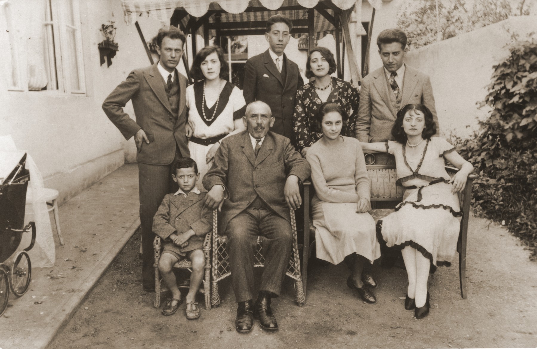 Portrait of the Vermes and Beck families taken outside Aladar Vermes' photo studio in Topolcany, Slovakia.

Pictured in the front row from left to right are: Robert Vermes, Adolf Beck, Manci Vermes and an unidentified cousin.  In the back row are: Aladar Vermes, Helena (Beck) Vermes, Pista Beck, Manci Beck and Ernest Beck.  Erika Vermes is in the baby carriage at the left.  Only Erika, Helena and Ernest survived the war.