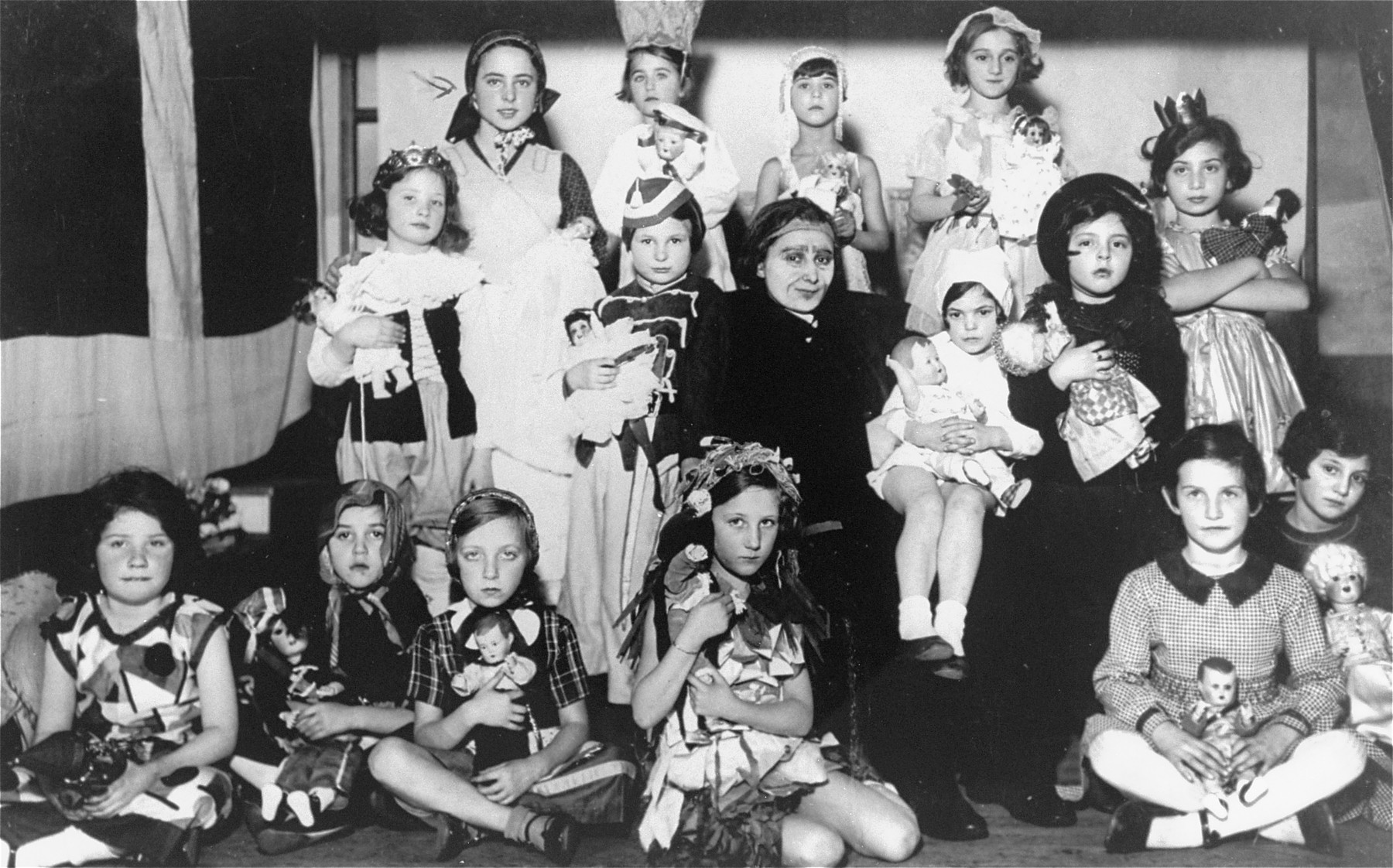 Group portrait of children at a costume party at the Carolinenskolen Jewish Girls' School in Copenhagen.  

The children are dressed as characters from Hans Christian Andersen's fairy tales.  The school was named after the Danish princess Caroline.