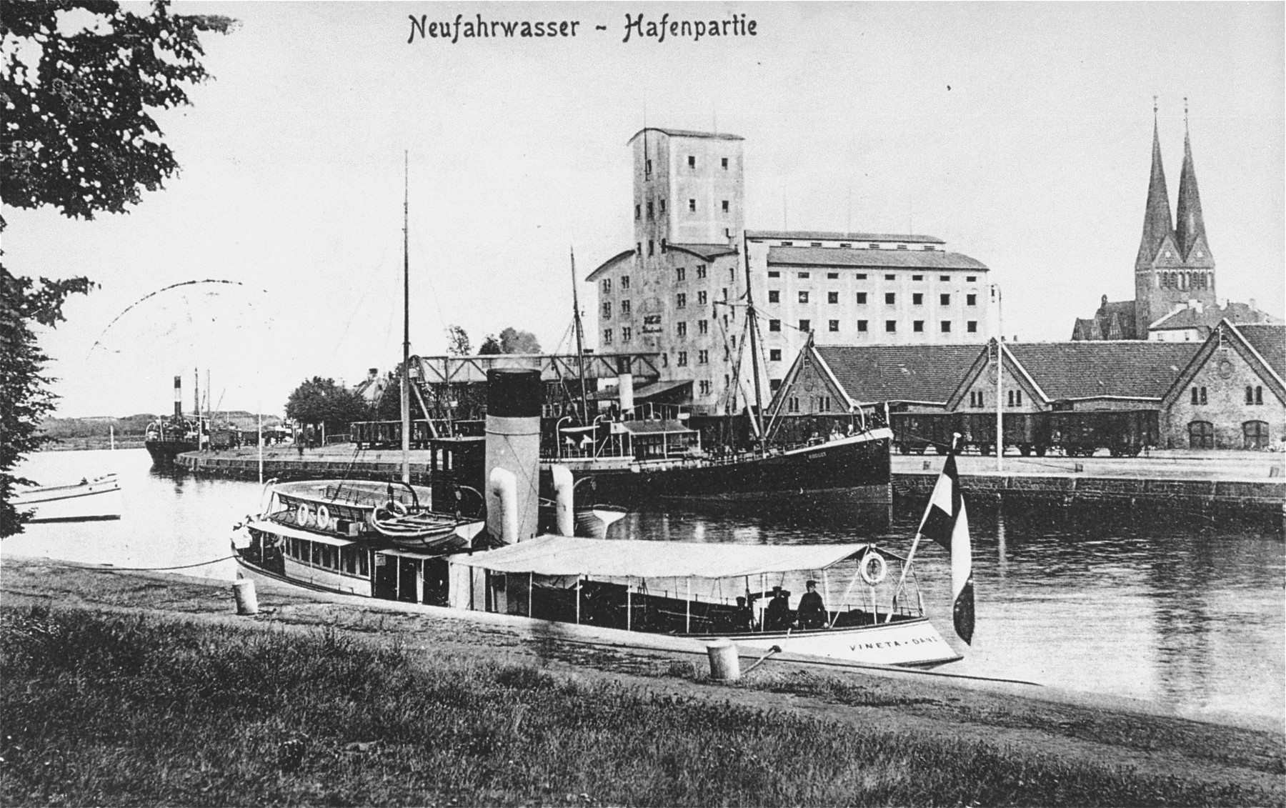 View of the city of Danzig.  

The silo in the center of the photograph belonged to the Anker family.  In the foreground is a tour boat.