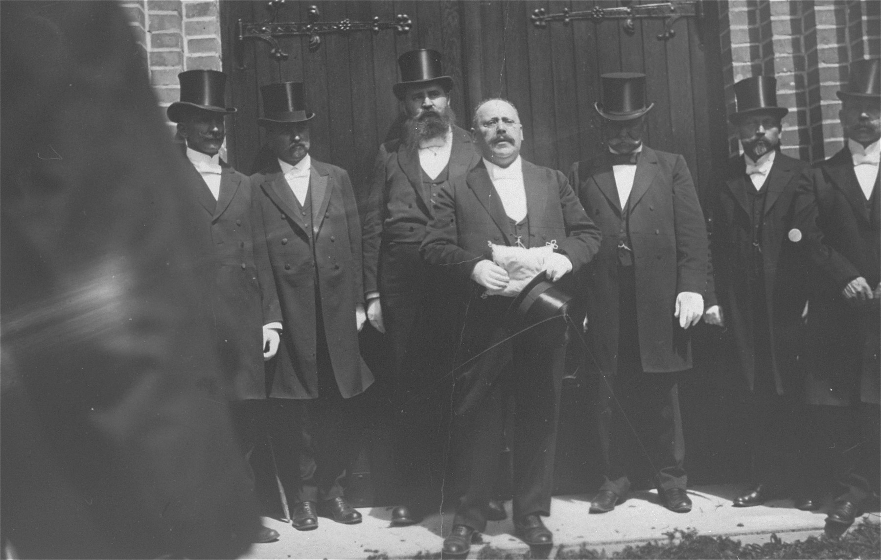 Prominent Jews dressed in top hats attend the dedication of the synagogue in Rastenburg, East Prussia.

Speaking is Max Jaruslawsky (the great-great uncle of the donor, George Fogelman).