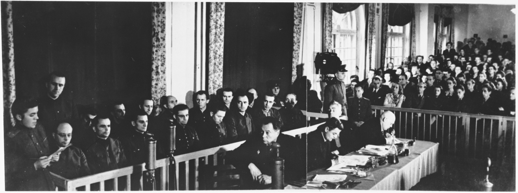 View of the courtroom at the Sachsenhausen concentration camp war crimes trial in Berlin.

The defendants are pictured at the left, their lawyers in the middle, and spectators at the right.