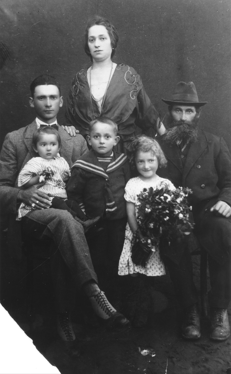 Studio portrait of the Katz family in Vilna.

George Katz (now Crane) stands in the middle surrounded by his parents, grandfather and younger sisters, Lola and Nechama.