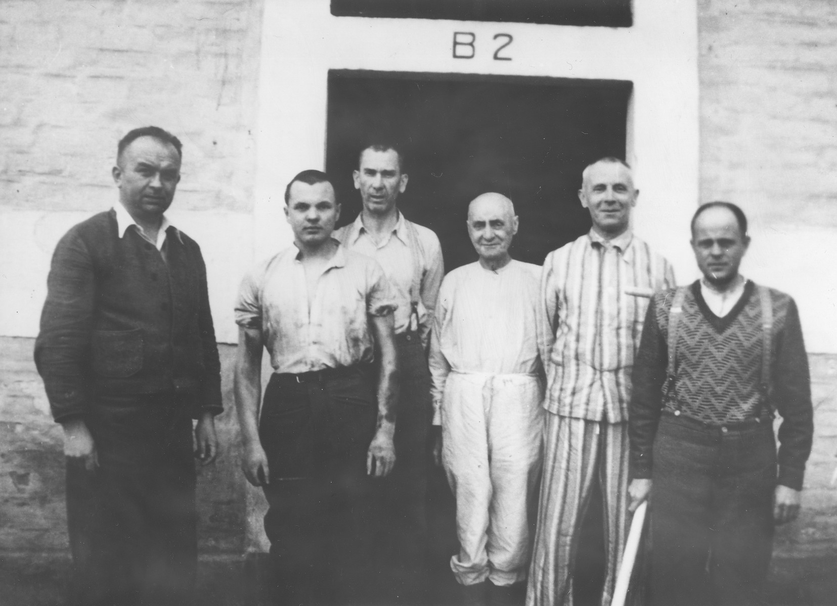 A group of Czech political prisoners stands in front of the infirmary in Theresienstadt.

Pictured from left to right are Dr. Vratil, Oskar Bartolsic, Captain Benak, unknown, Colonel Stribrny, and Sgt. Stovicek.