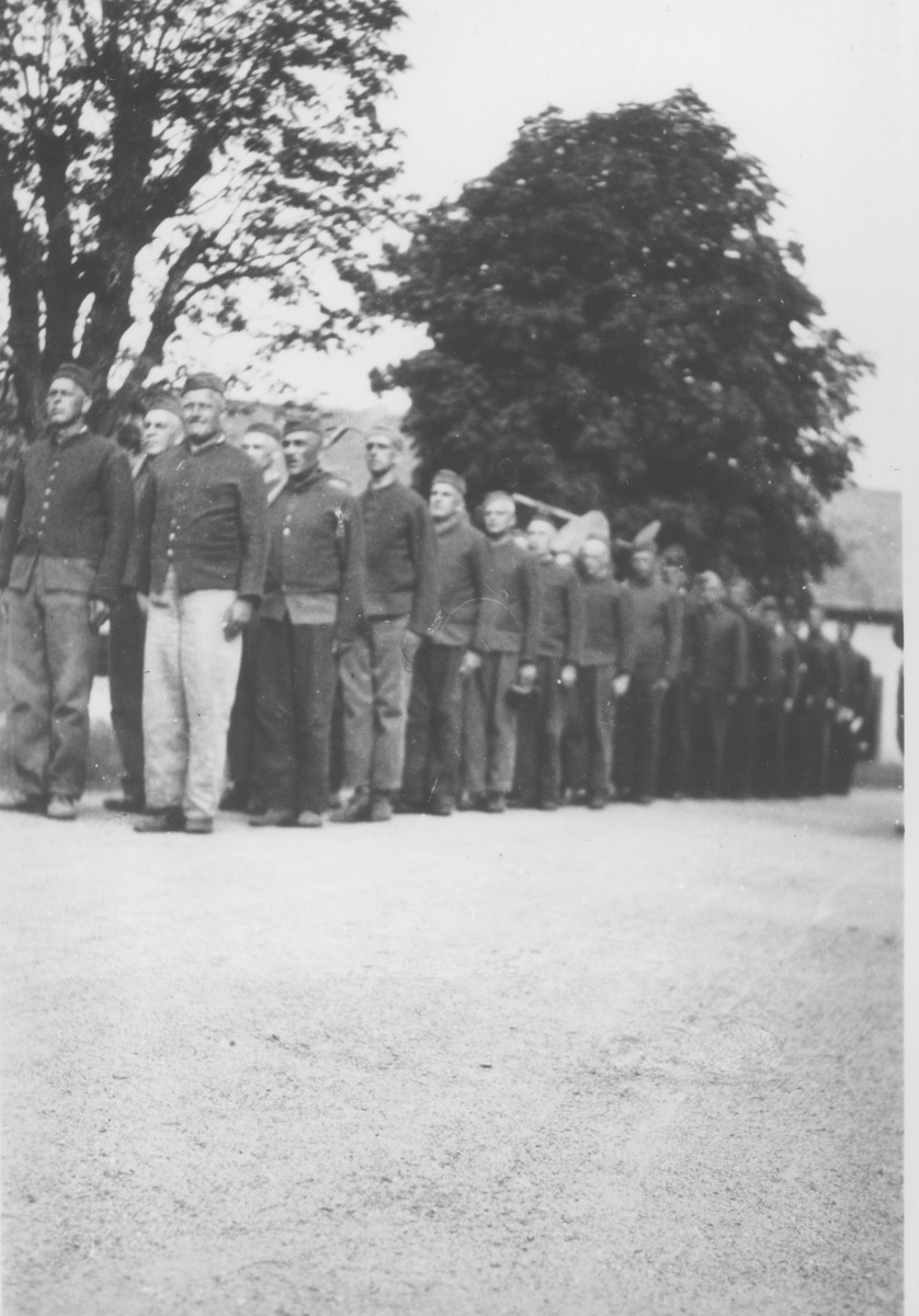 A group of Czech political prisoners interned in Theresienstadt stand in formation as they reenter the camp after a day at forced labor.

Among those pictured is Oskar Bartolsic.