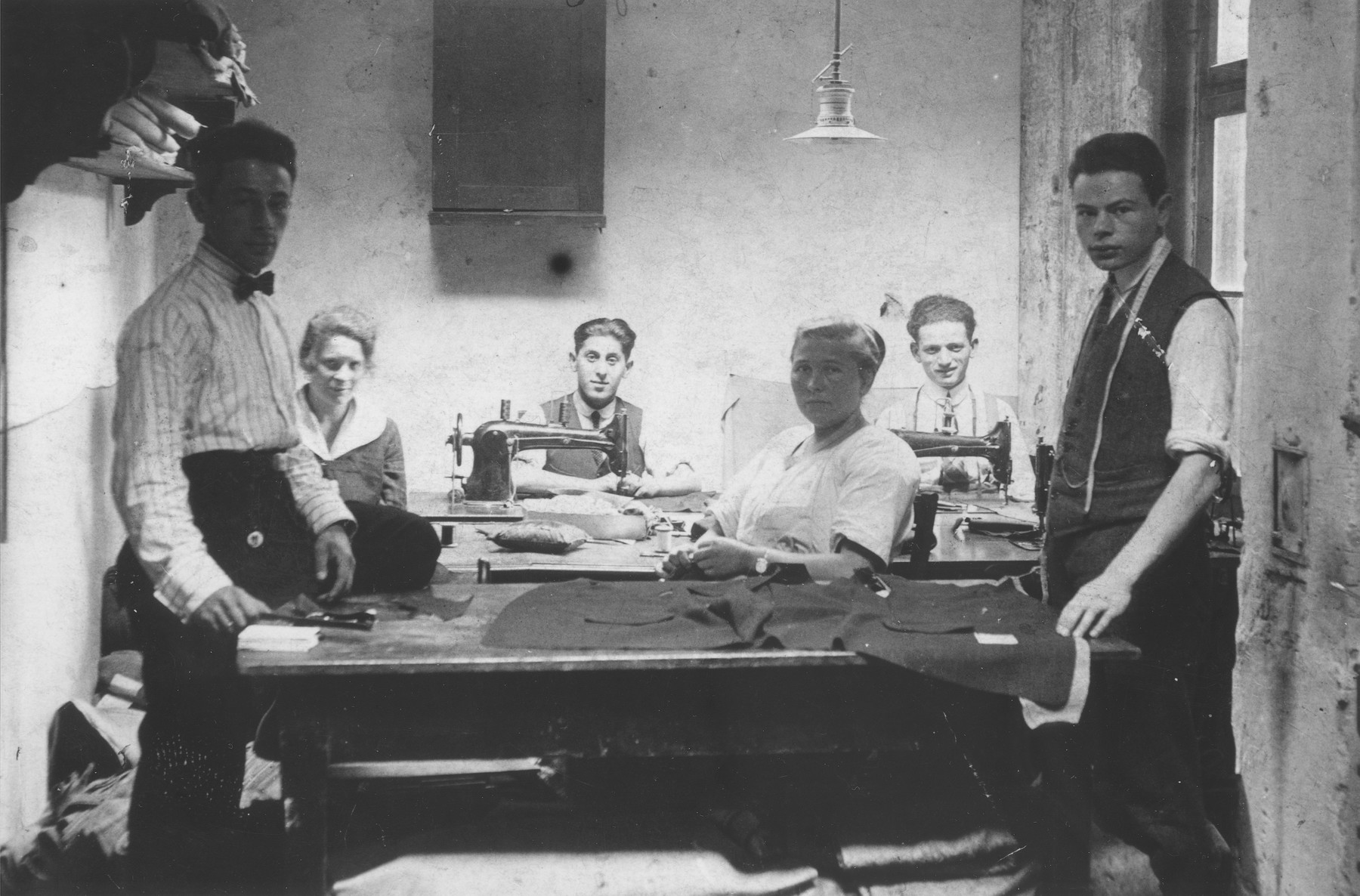 Jews at work in a tailor shop owned by Natan Wolf Lewkowicz in Bedzin, Poland.

Among those pictured is Natan Wolf Lewkowicz, the donor's father.