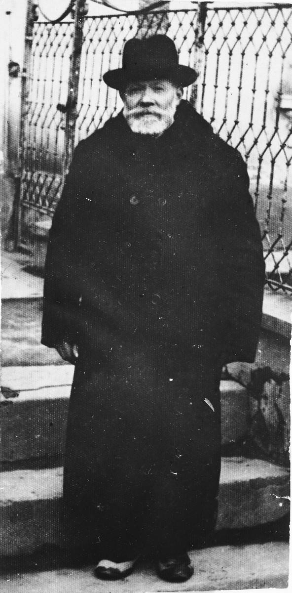 Nachman Aschkenase stands in front of the steps to a building.