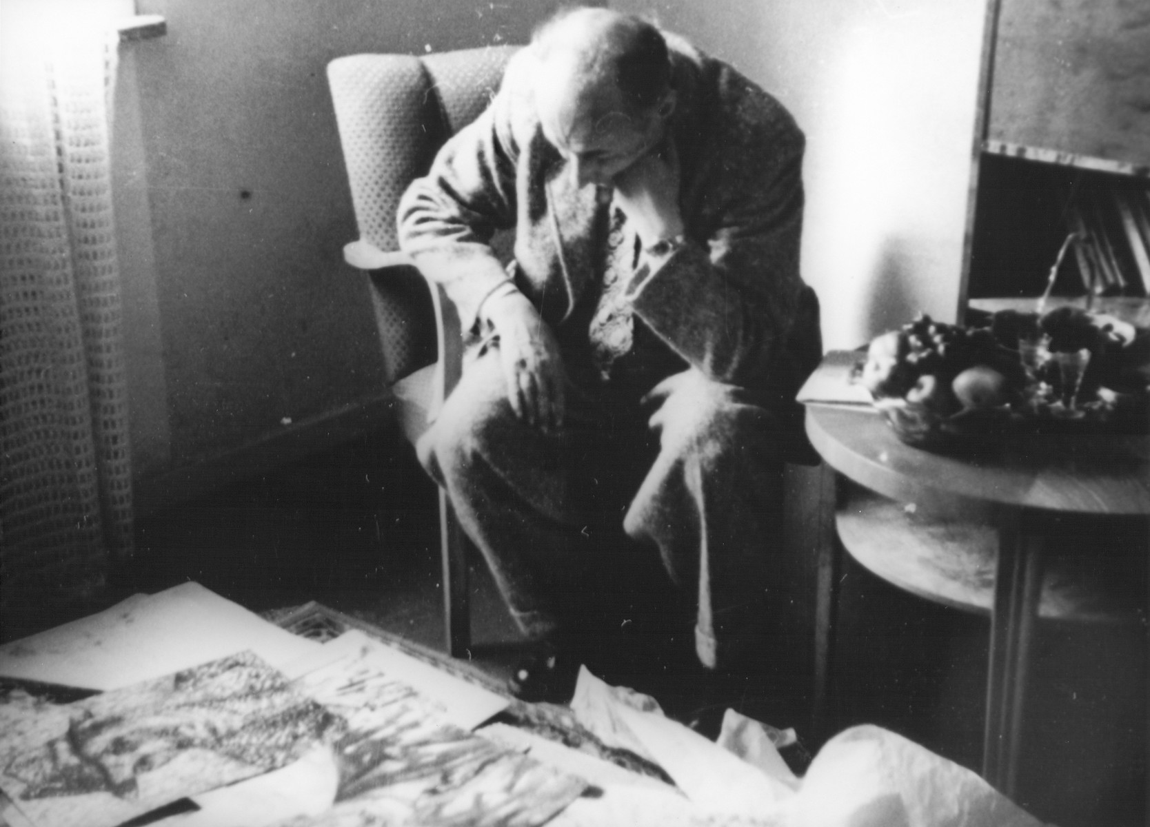 In the apartment of Nachman Zonabend, Lodz ghetto artist Josef Kowner looks at a collection of forty-five of his paintings that were rescued by Zonabend from the ghetto. 

Josef Kowner died in Sweden in 1968.