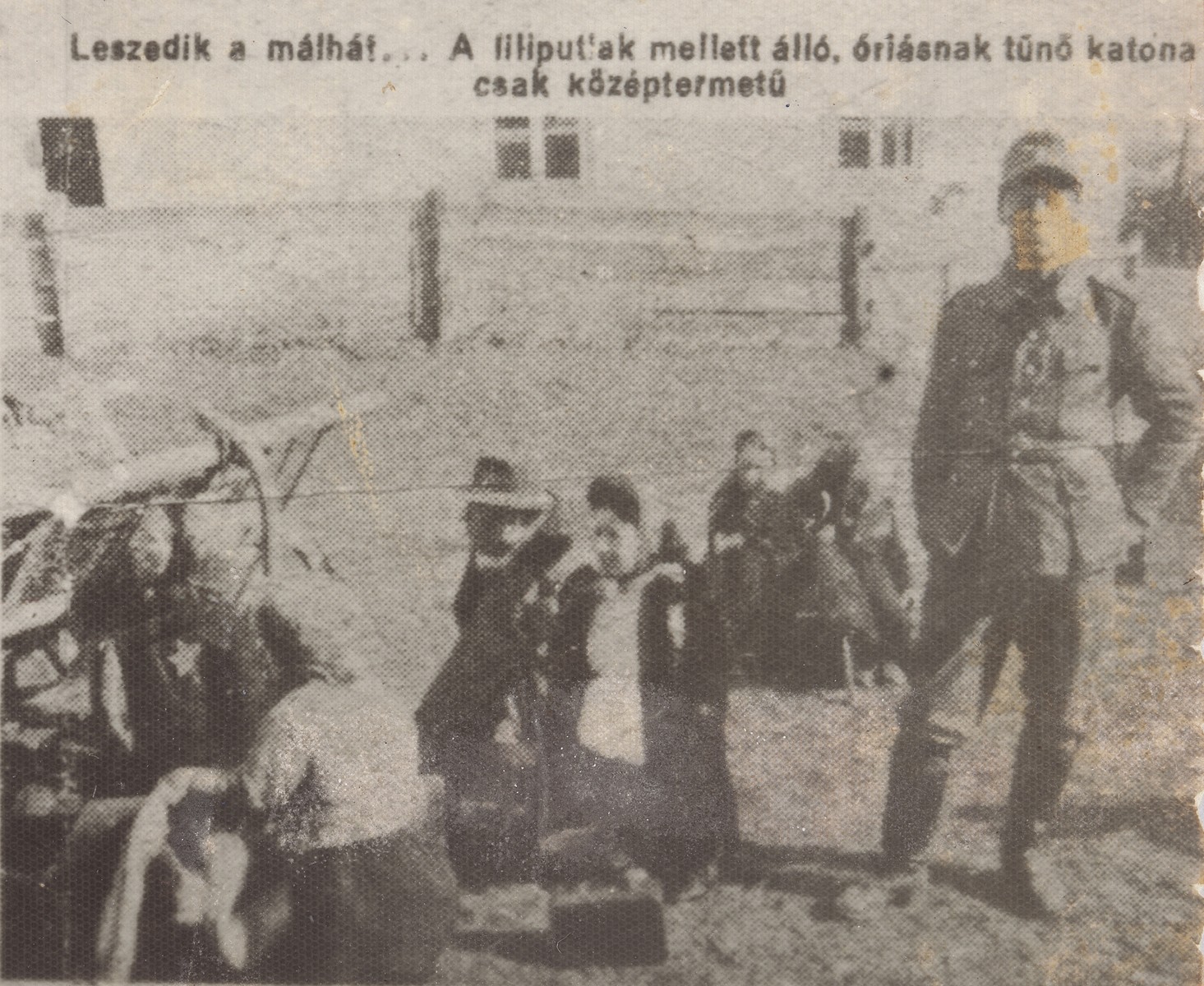A German soldier stands next to a group of Jewish dwarves as they remove their bundles from a farm wagon.

The dwarves are members of the Ovici family.  The newspaper caption reads: "They take their bundles from the cart... the soldier standing next to them appears to be a giant, even though he is only of average height."