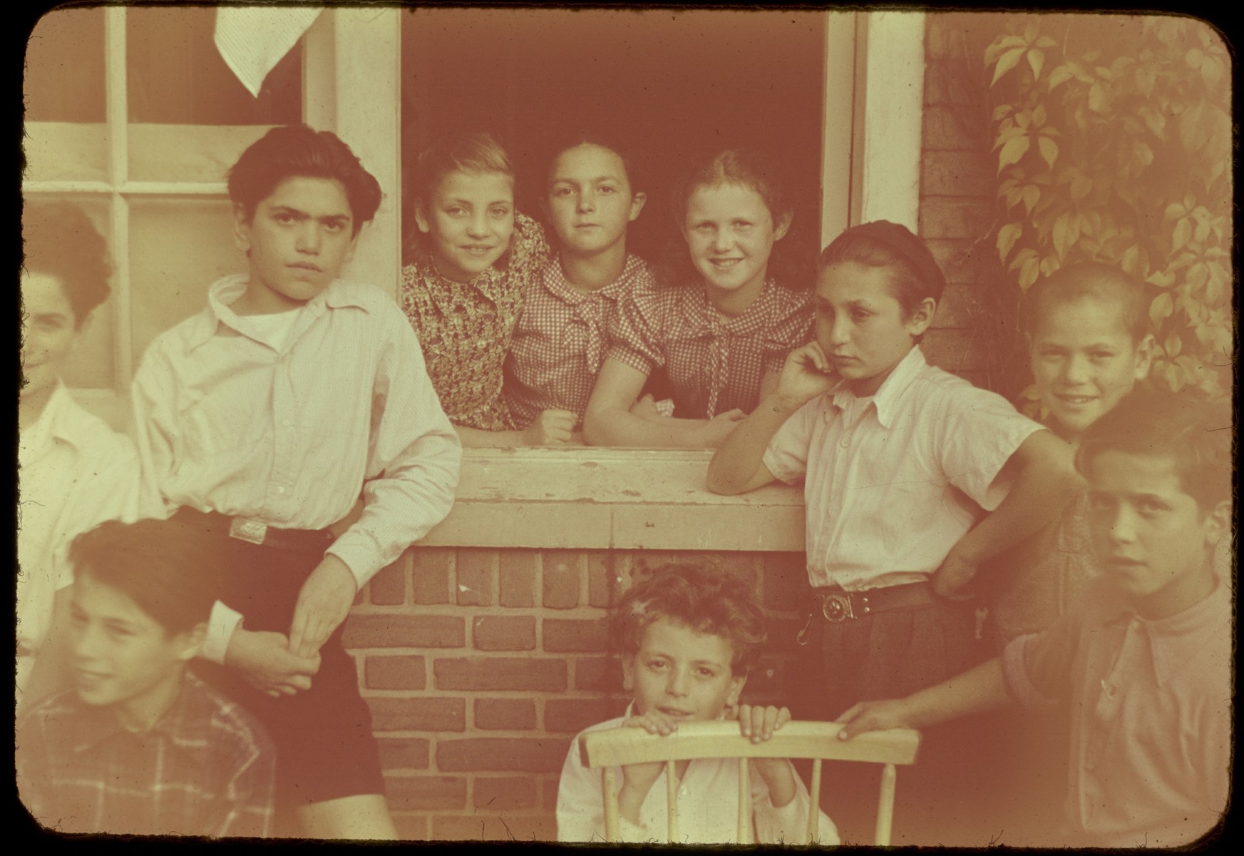 Jewish DP children pose in and around the window of the Kibbutz Ilaniah children's home in Apeldoorn.