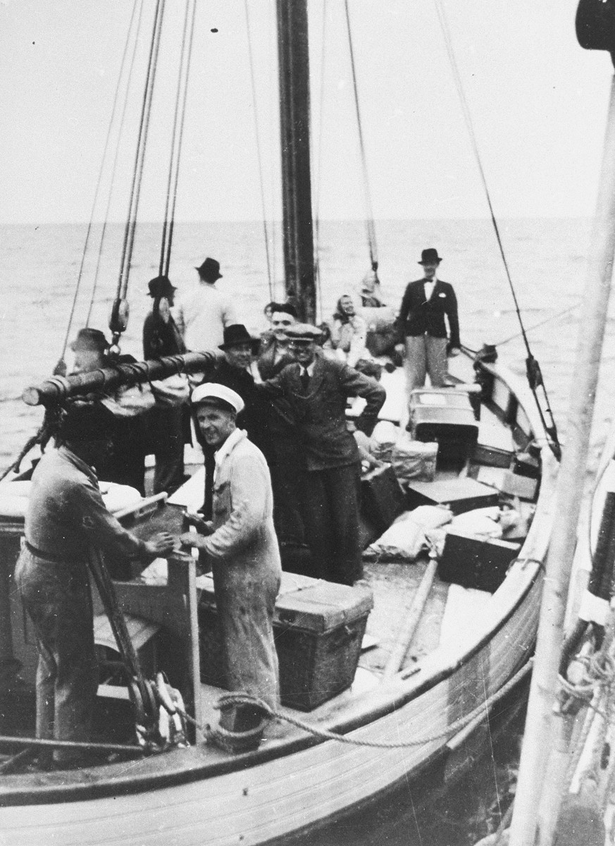 Danish fishermen (foreground) ferry a boatload of fugitives across a narrow sound to neutral Sweden.  

Caption from the Danish Museum reads: "Transfer of passengers from a Danish ship to a Swedish one in the waters between Denmark and Sweden. Picture from a slideshow compiled to document the activities of the escape organisation Danish-Swedish Refugee Service run by Mr. Leif Hendil. The pictures were probably all taken shortly before the German capitulation in May 1945, and the refugees are thus unlikely to be Jewish."