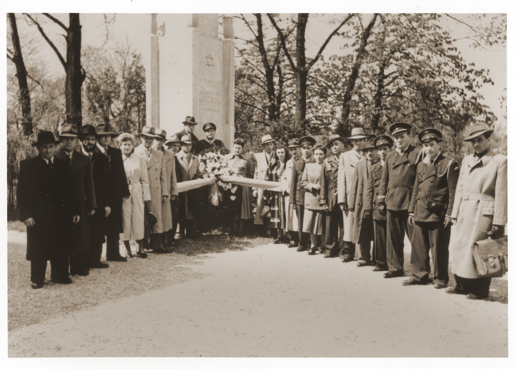 Jewish DPs from the Lechfeld displaced persons camp pose with a wreath in front of the memorial to Jewish victims at the Dachau concentration camp.