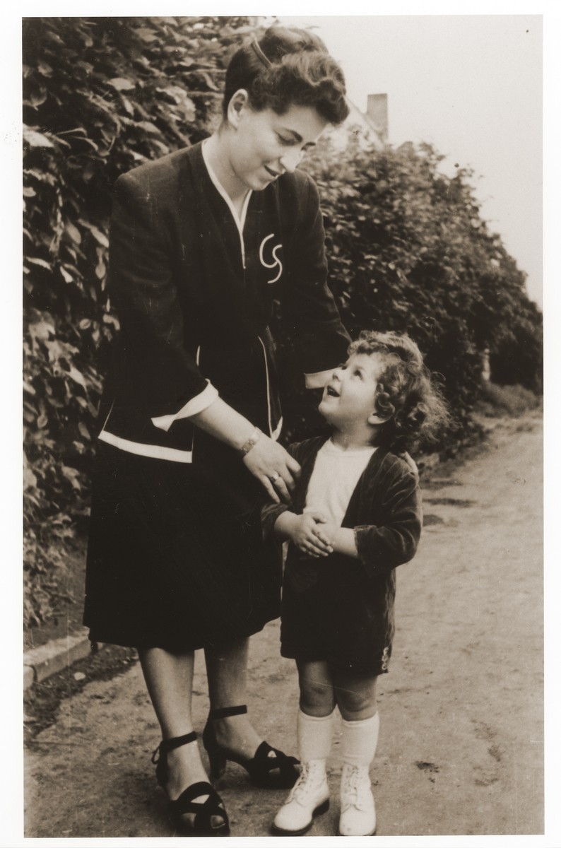 Mrs. Kolanchik talks to her son in the Lechfeld displaced persons camp.

Gerzon Trzcina was born in Krasnosielc, Poland in 1922.  He was the son of Dina Kassel and Benam Yitzhak, who was a businessman in the leather trade.  Gerzon had one older brother, Jacob, and two sisters, Faiga (b. 1918) and Perl (b. 1920).  When the war broke out, Gerzon was working as a photographer's assistant (among other jobs) in Warsaw.  Following the German invasion of September, 1939, Gerzon was slightly wounded by shrapnel.  Soon after, a drunken German soldier, forcibly cut Gerzon's hair.  When the soldier made him stoop down to pick up the cuttings, Gerzon grabbed the German's gun and ran away.  After a short time in hiding, Gerzon returned to his hometown, where he learned that eighty Jews had been murdered in the synagogue during the first week of the war in one of the first large-scale atrocities against Polish Jews.  Among those killed was Gerzon's eighty-two-year-old grandfather, Haskel Kassel.  Gerzon moved on to Makow Mazowiecki, where he was forced to clean the stables the Germans had set up in the town's synagogue.  In the late fall, Gerzon escaped with his family to Bialystok, where he worked in a tannery until the family was deported to the Soviet interior in June, 1940.  Along with a group of Polish and Jewish refugees, the Trzcinas were sent to the Kiltovo labor camp in northern Russia.  Harsh conditions and poor nutrition led to Gerzon's father's death in the camp.  The family remained in Kiltovo until the German invasion of the Soviet Union in June of 1941.  Soon after, the refugees were allowed to leave the camp, and the Trzcinas moved to nearby Syktyvkar (capital of the Komi republic), where Gerzon worked in a construction company and later in a tannery.  In Syktyvkar, Gerzon was reunited with Gittel Blankitner, a Jewish refugee from Mlawa, whom he had met earlier in his travels in the Soviet Union.  (Gittel's father perished in Aushwitz, and her mother and siblings were killed in Treblinka.) In November, 1944, Gerzon and Gittel were married. The couple left the Soviet Union with their new baby in 1946.  Returning for a brief time to Poland, the family soon joined the wave of survivors streaming toward the Western zones of occupation.  After their arrival in Germany, the Trzcinas stayed in several DP camps including Vilseck, Wurzburg and Lechfeld, where Gerzon worked as an UNRRA photographer.  In March 1951, the family immigrated to the United States.