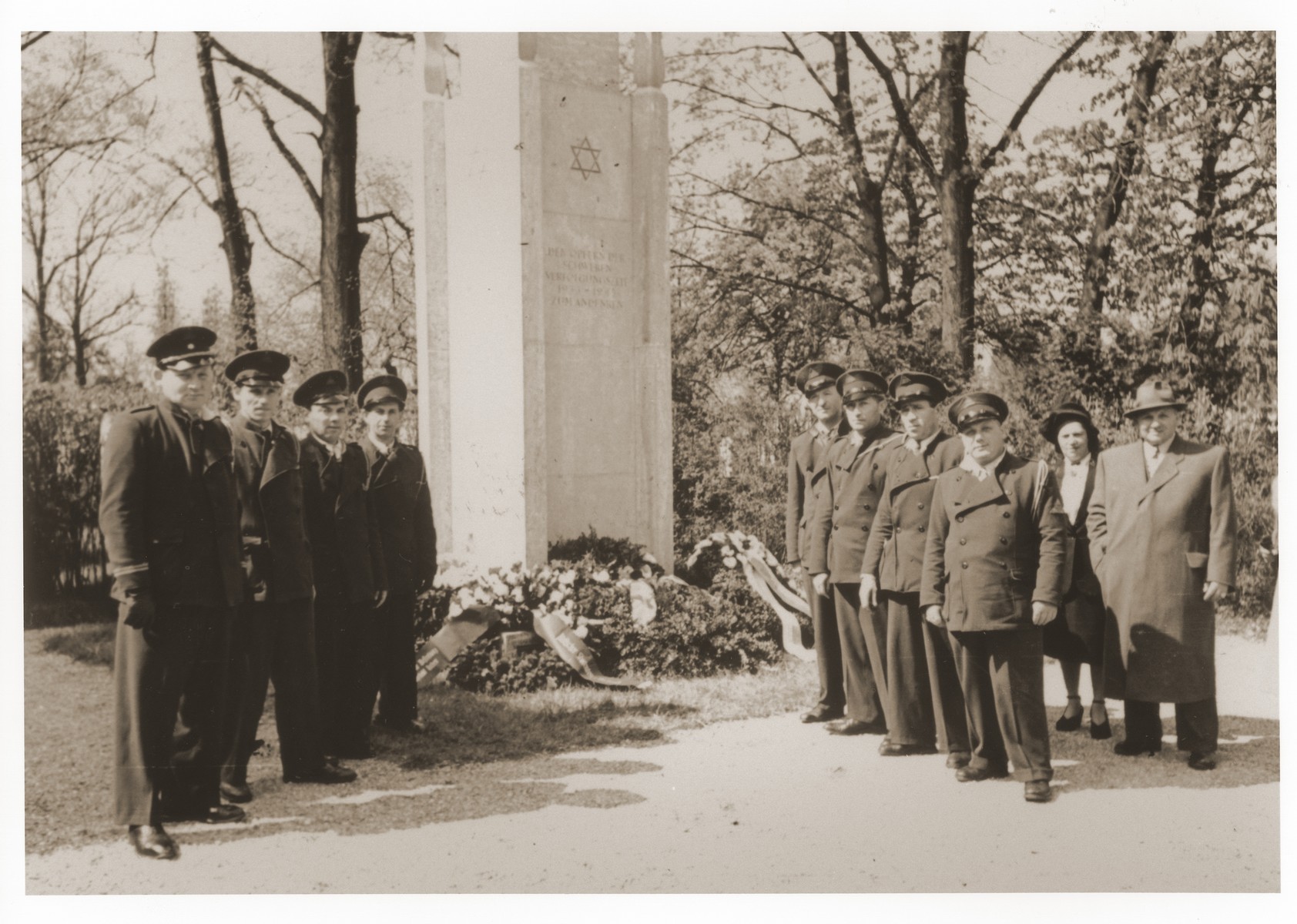 Jewish DP police from the Lechfeld displaced persons camp pose in front of the memorial to Jewish victims at the Dachau concentration camp.