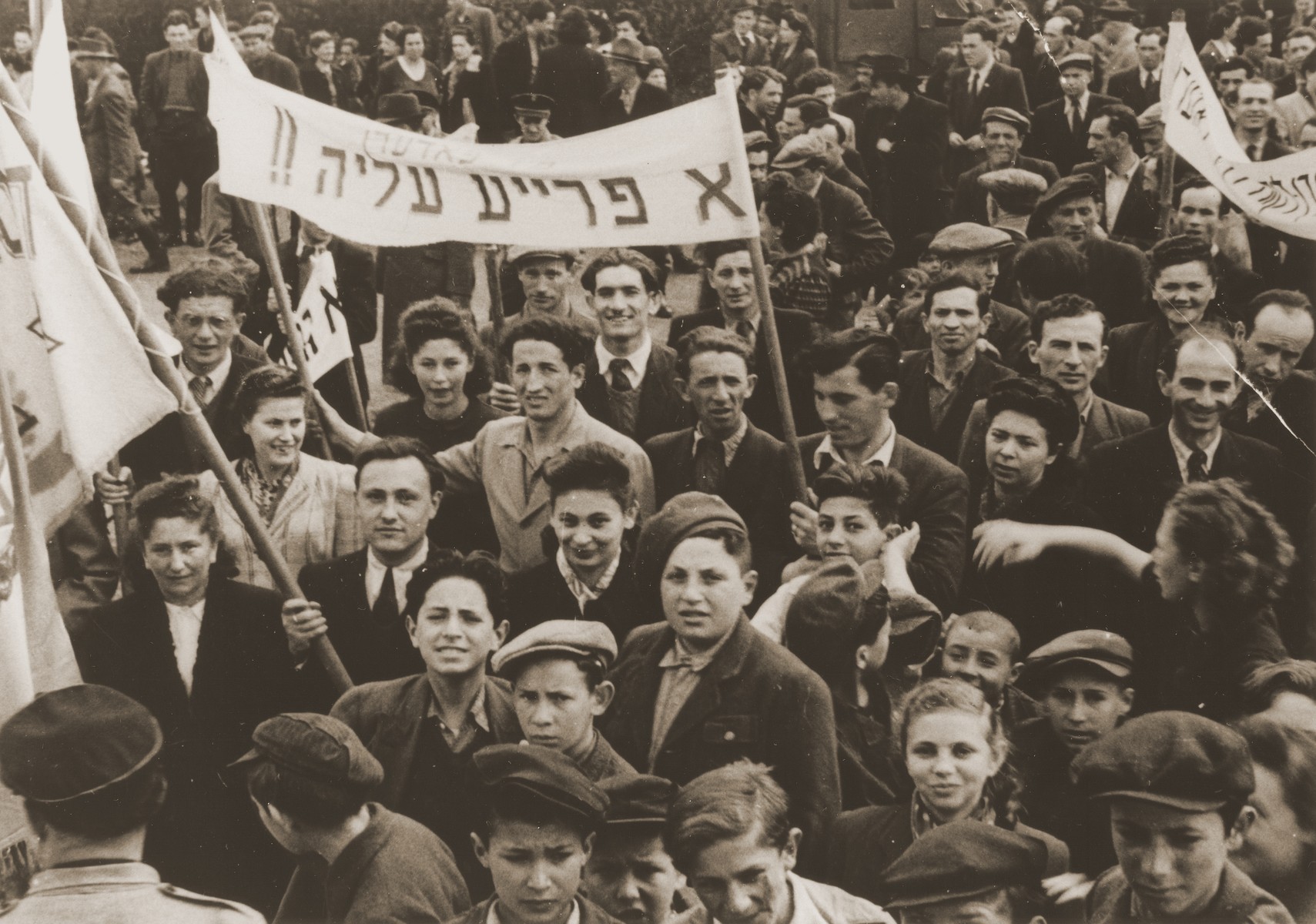 Jewish DPs in the Feldafing displaced persons camp participate in a demonstration calling for a policy of free immigration to Palestine.

The Yiddish banner reads, "We support free aliyah [immigration]."