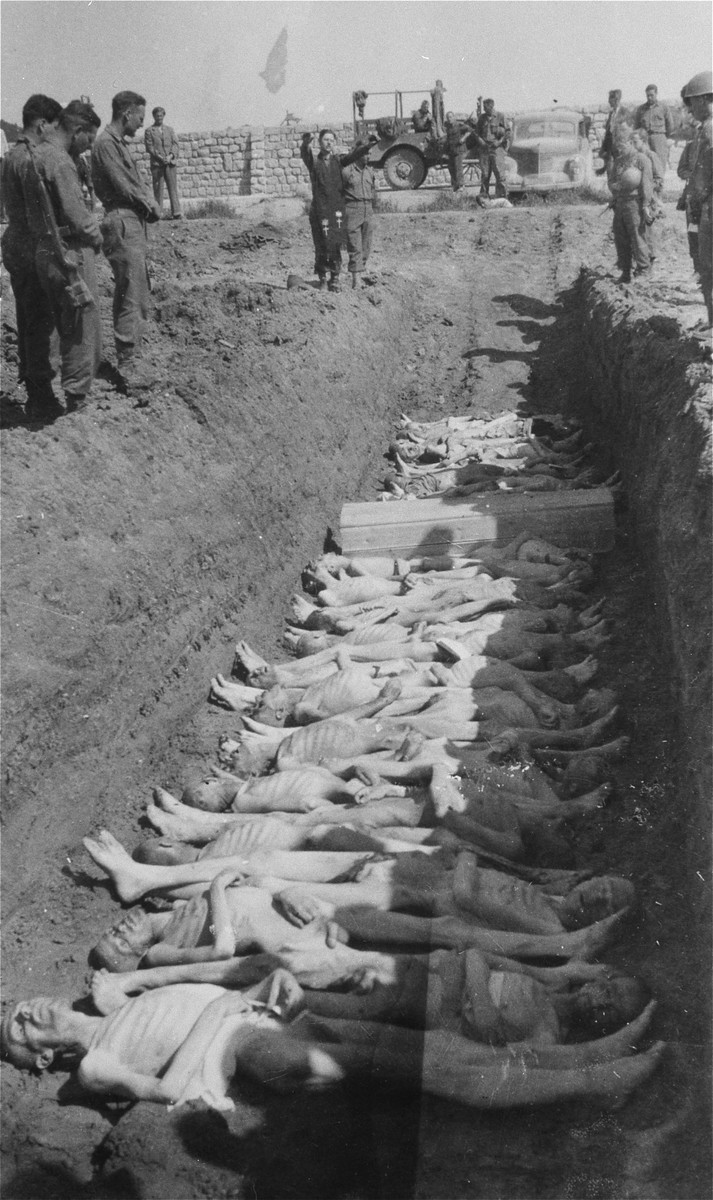 An American Army chaplain recites prayers at an open mass grave in the Gusen concentration camp.