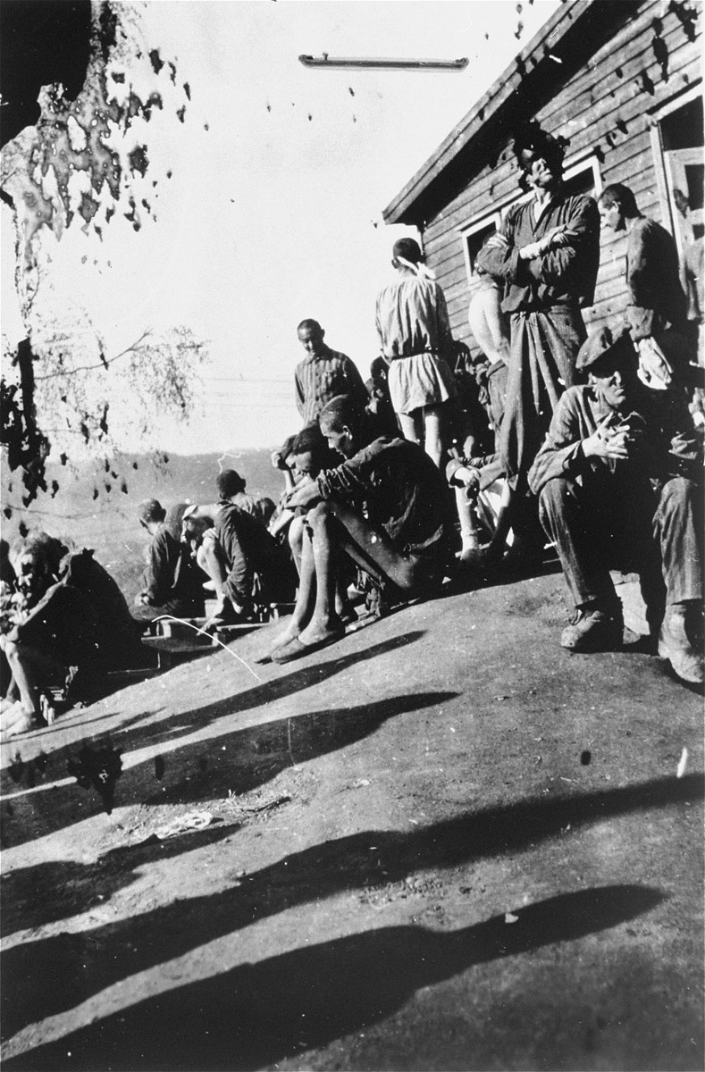 Survivors [probably of Gusen] stand outside of a barracks.