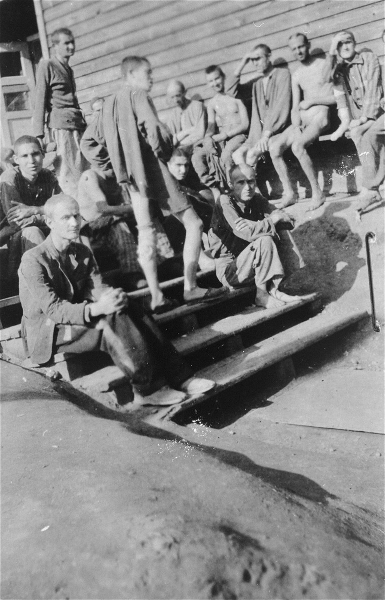 Survivors [probably of Gusen] gather outside a barracks.