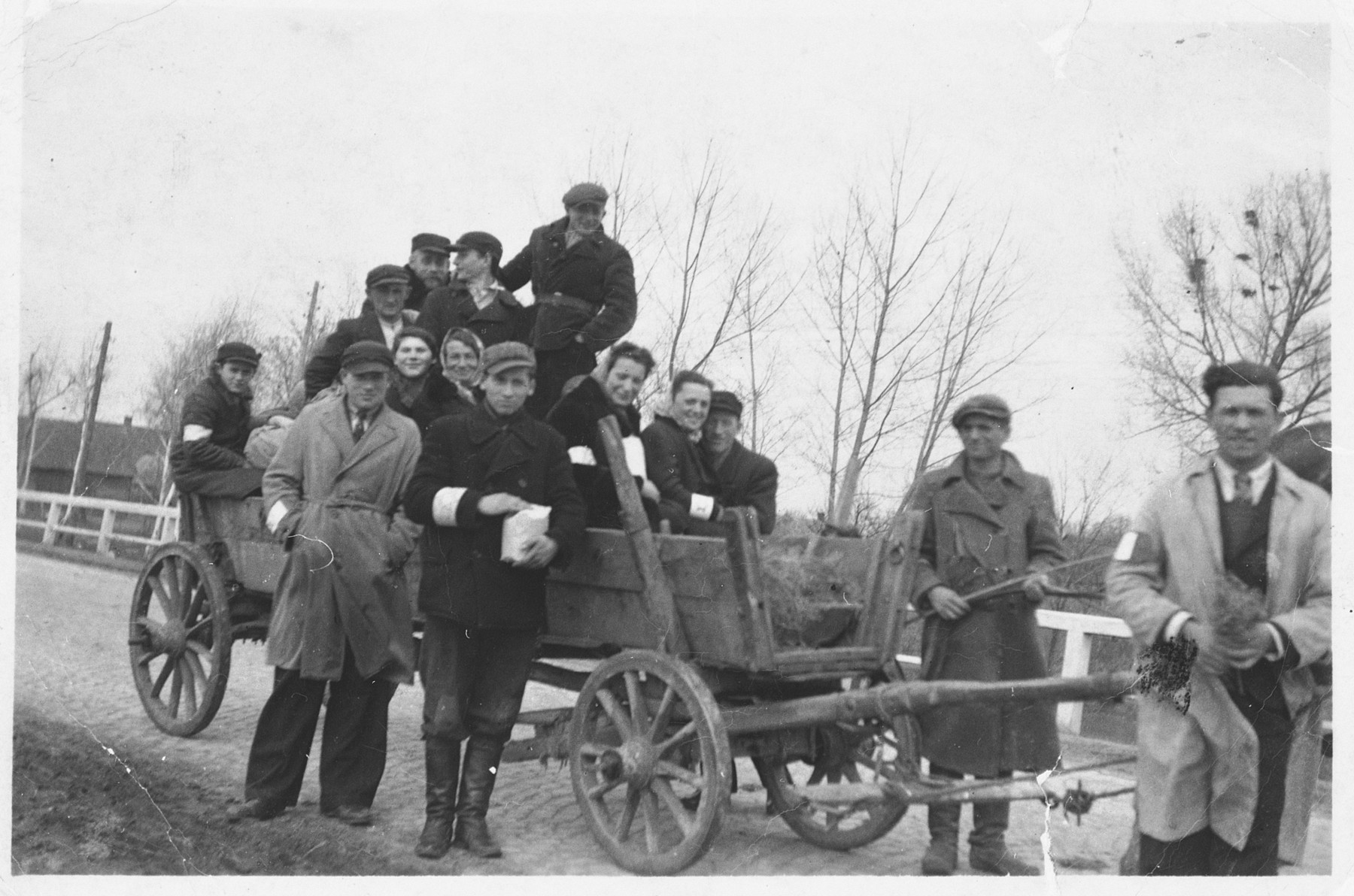 A group of Jewish friends wearing armbands poses on and around a hay wagon near Radom shortly after the German invasion of Poland.