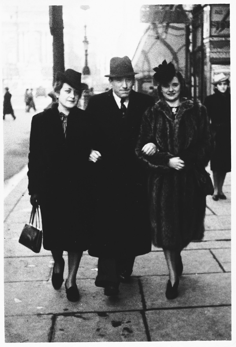 A Jewish couple strolls with a friend along a street in German-occupied Brussels.

Pictured on the left are Lea and Mendel Abramowicz.