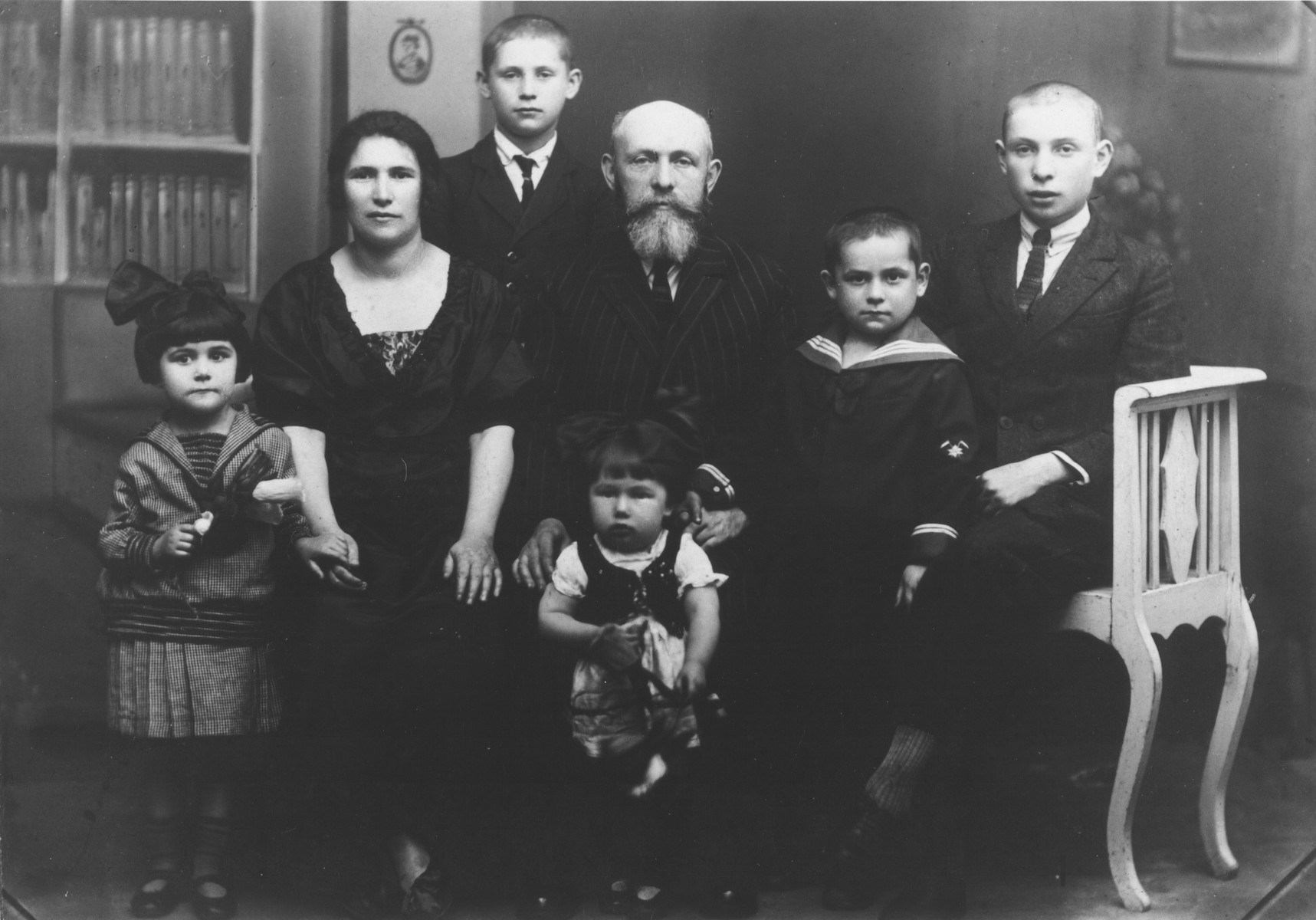 Studio portrait of a Jewish family in interior Poland.

Pictured are Yechial Yosef Szwimer, his wife Raiza 
Bella Godfried Szwimer and their children: sons Zvi, Yehuda, Yitzhak or Zerach, and daughters Tova and Rachel. Yechiel was born in Bedzin, Poland to Moshe Yechiel and [mother's name unknown]. Yechiel served  in the RAF in Ramat David in Israel, and died in 1967.


Pictured in the center are Aaronl Szwimer with some of their eleven children.