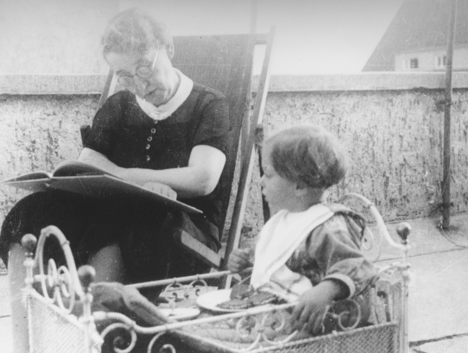 A Jewish woman reads to her granddaughter on the terrace of her home in Kassel, Germany.

Pictured are Mrs. Lindenfeld with Dorrith Oppenheim.