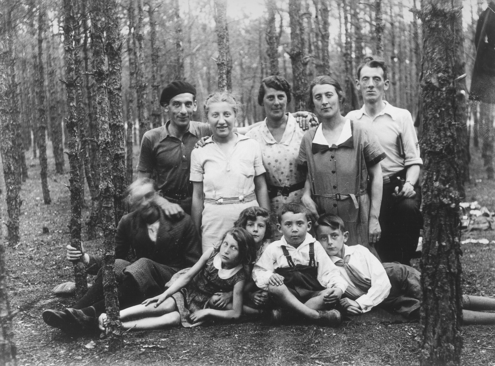 Group portrait of members of an extended Jewish family on an outing to the Wolboz Forest near Piotrkow Trybunalski, Poland.

Pictured are members of the Wolrajch family.  The photograph was taken during the visit of a cousin, Helen Tolep, from the U.S.  Pictured in the back row from left to right are: Joel Wolrajch, Helen Tolep, Rachel Wolrajch (wife of Hersh Lieb), Chia Sura Wolrajch and Hersh Lieb Wolrajch.  Sitting in front are: Shaya Wolrajch (blurred), Rachel Fish, Ginka Wolrajch, wolf, and Chiemic Wolrajch.
