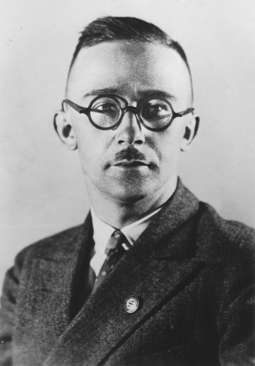 Studio portrait of Heinrich Himmler wearing a Nazi party pin on his lapel.