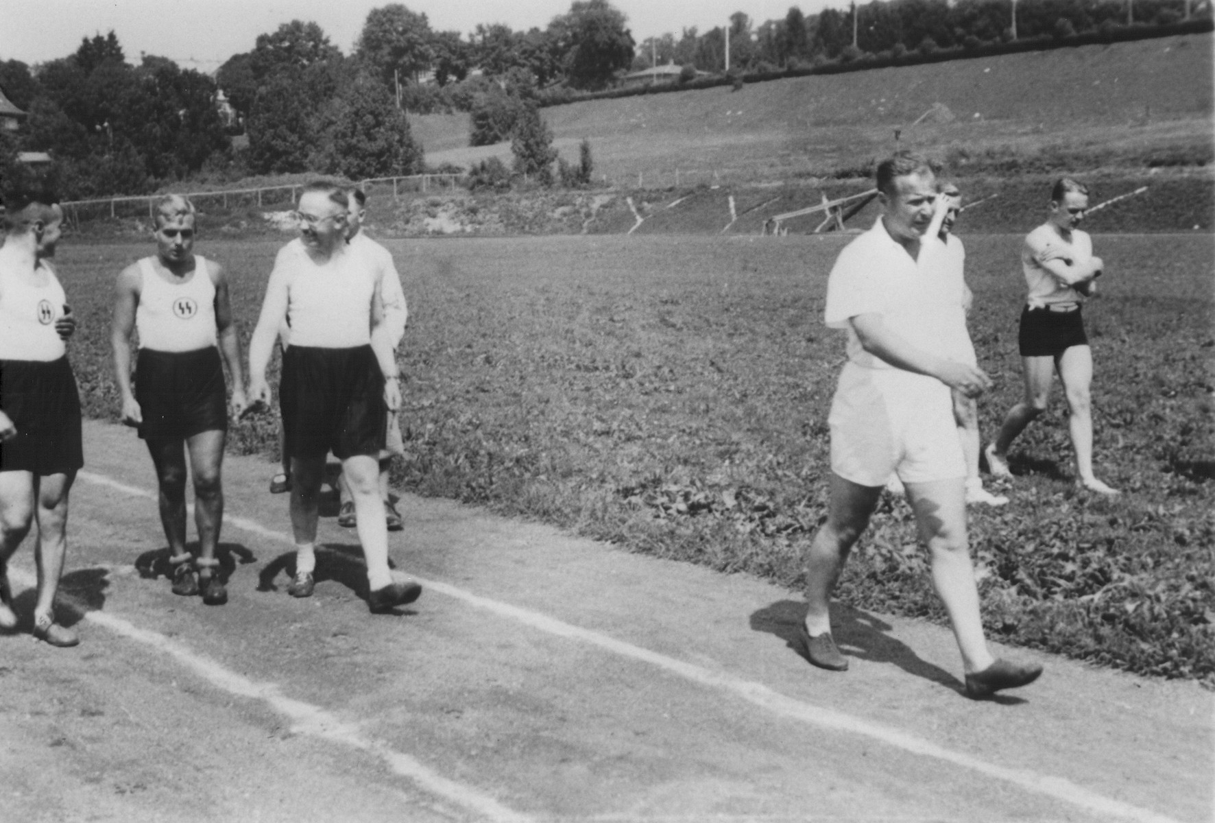 Heinrich Himmler walks along an outdoor track at the SS officers school in Bad Tolz, Germany.

Also pictured is Himmler's adjutant Karl Wolff (ahead of Himmler in the white shirt and shorts).