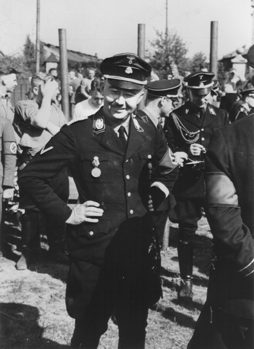 Reichsfuehrer-SS Heinrich Himmler poses outside among other SS officers.

Pictured at the right is Karl Wolff.