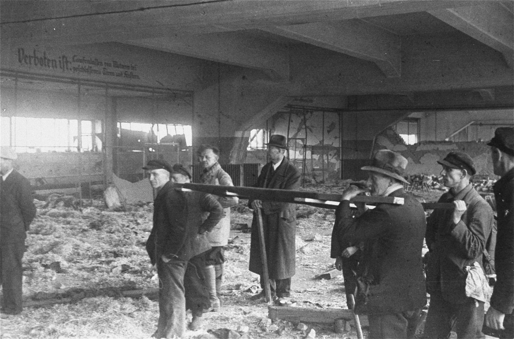 German civilians from the town of Nordhausen remove corpses from the central barracks (Boelke Kaserne) in the Nordhausen concentration camp.