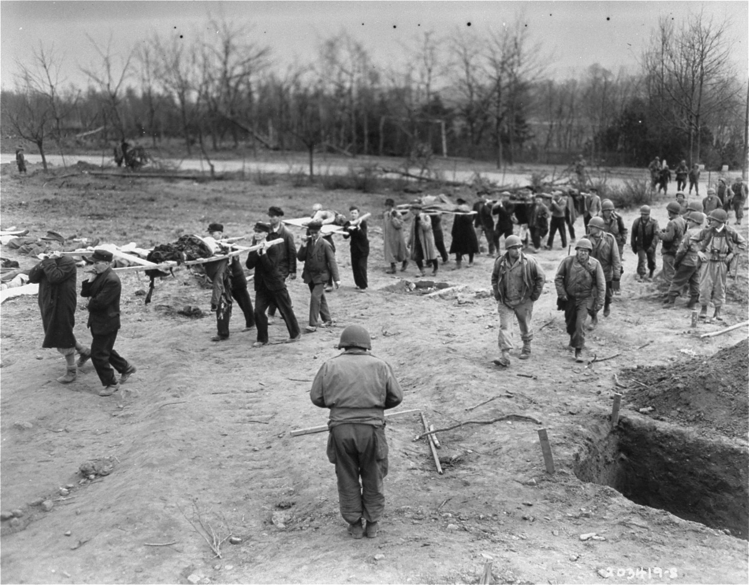 German civilians from the town of Nordhausen carry the bodies of prisoners from the Nordhausen concentration camp to mass graves.