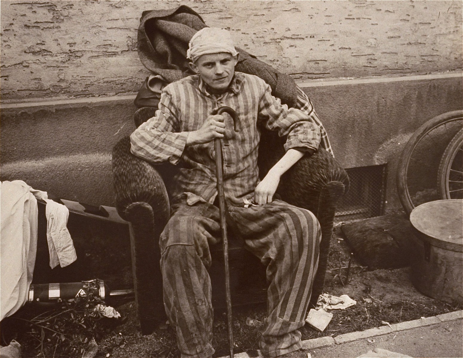 A survivor in Nordhausen relaxes in an easy chair confiscated by American troops from camp personnel.