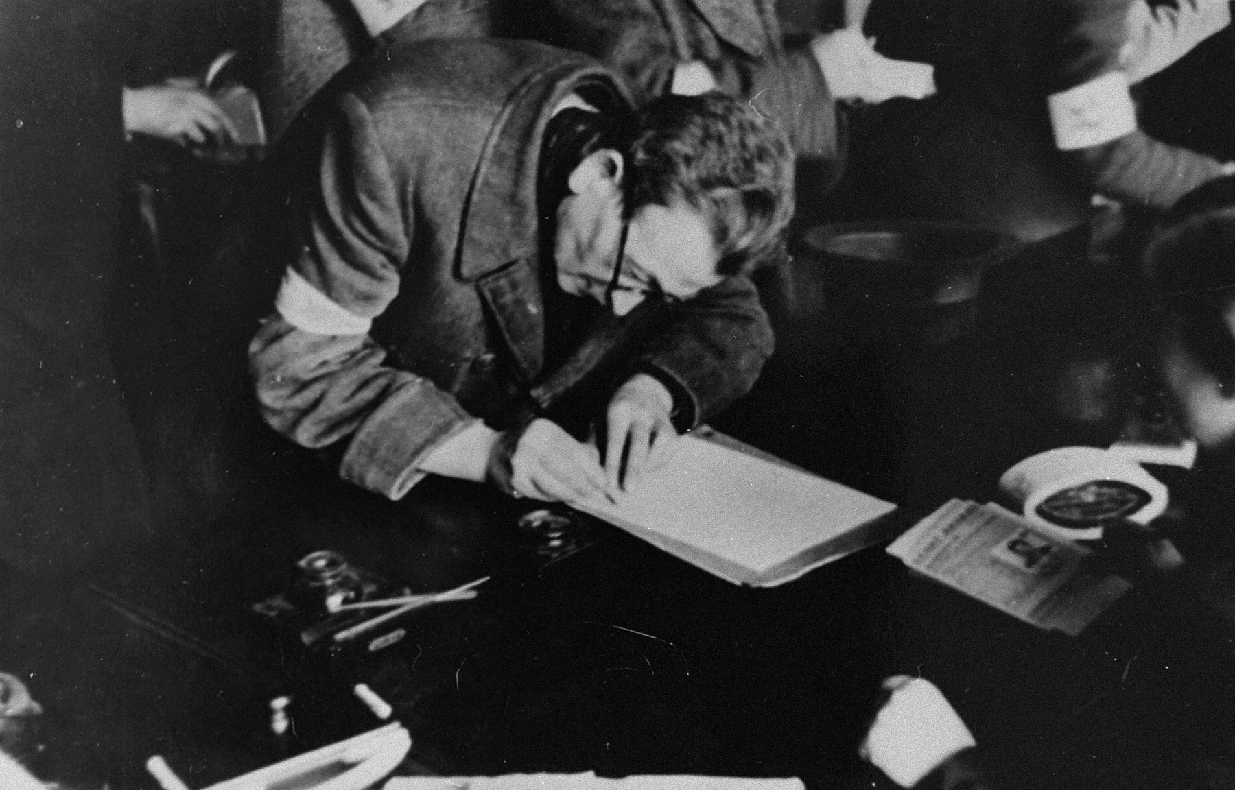 A Jew fills out a form to obtain an identification card in one of the ghetto offices.
